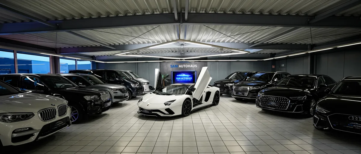 Showroom von SAM Autohaus mit weißem Lamborghini und weiteren Fahrzeugen