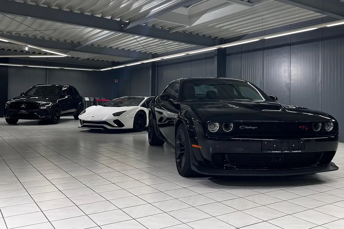 Showroom von SAM Autohaus mit Lamborghini, Dodge Challenger und weiteren Fahrzeugen